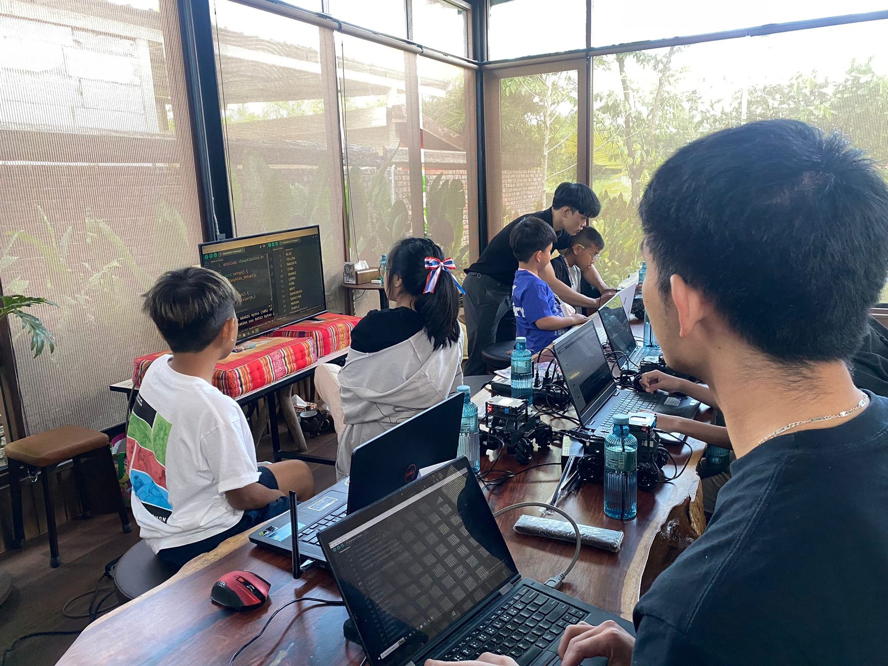 Students coding robots together on laptops during an MBX Robotics workshop